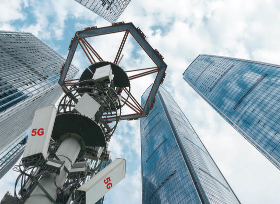 Low angle view of 5G antenna with modern skyscrapers and financial buildings
