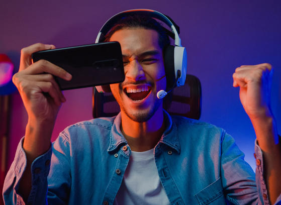 Man holding phone wearing headphones