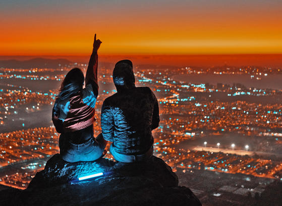 Couple overlooking the city. Night time with dramatic landscape