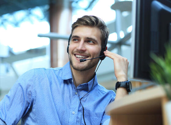 Man with headset talking on the phone at a helpdesk 