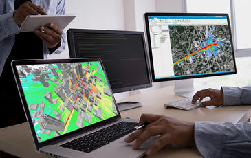 Person sitting in front of two monitors with Planet software