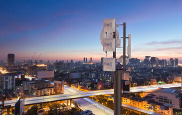 5G tower with a dark city background