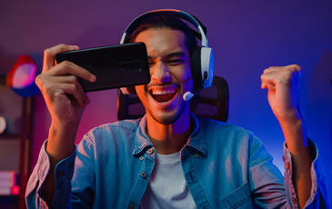 Man holding phone wearing headphones