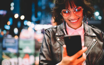 Happy female having a video call with headphones at night
