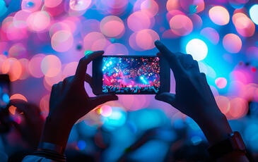 Silhouettes of people holding phones to take pictures at a concert