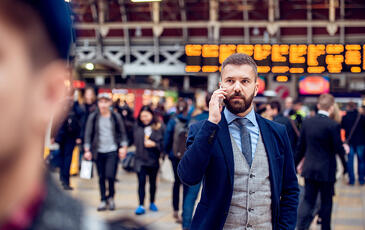 Busy businessman with smartphone, making phone call at airport