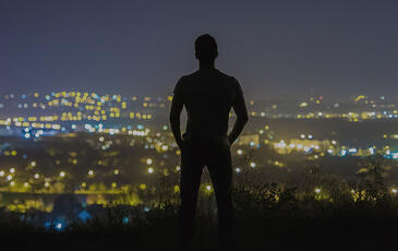 Man overlooking city at night