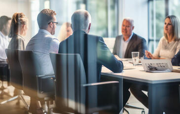 A group of business partners engaged in a meeting inside a modern conference room