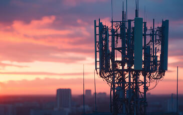 5G communication tower at sunset overlooking cityscape 