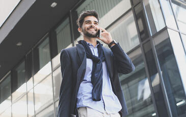 Business talking on the phone while walking in the city