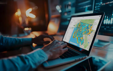 Business professional using Planet Cloud on laptop to design and optimize fixed wireless access (FWA) networks faster.