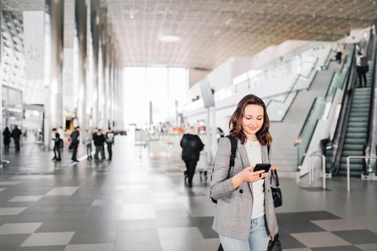 Woman at airport holding a phone