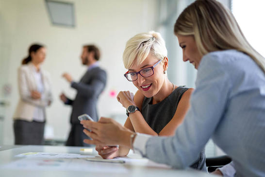 Two women looking at a mobile phone