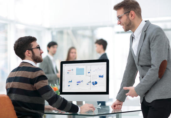 Two men discussing reports in the office