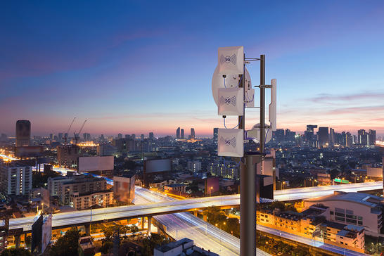 5G tower with a dark city background
