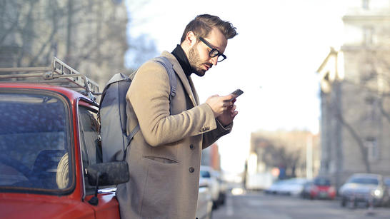 Man looking at phone on the sideway