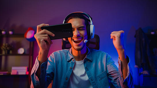 Excited guy viewing OTT video application on his mobile phone