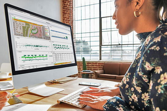 Businesswoman analyzing a network testing analytics report on TEMS Cloud dashboard