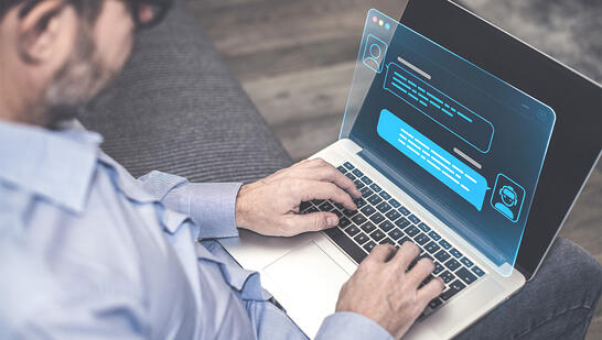 Man chatting on a laptop, representing VistAI ASK enabling natural‑language queries across diverse data sources.