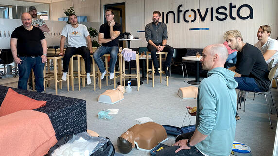 Employees participate in an office CPR training session, getting hands-on with lifesaving skills.