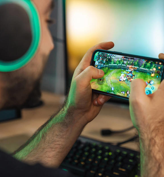 Man with headphones playing game on mobile device