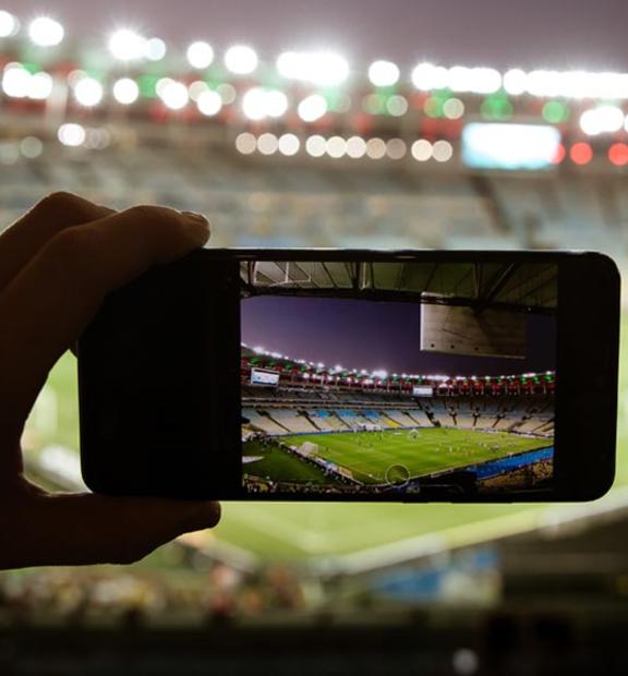 Taking photo with mobile phone on large sports arena