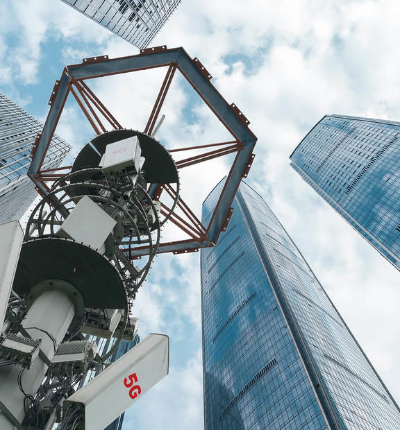 Low angle view of 5G antenna with modern skyscrapers and financial buildings