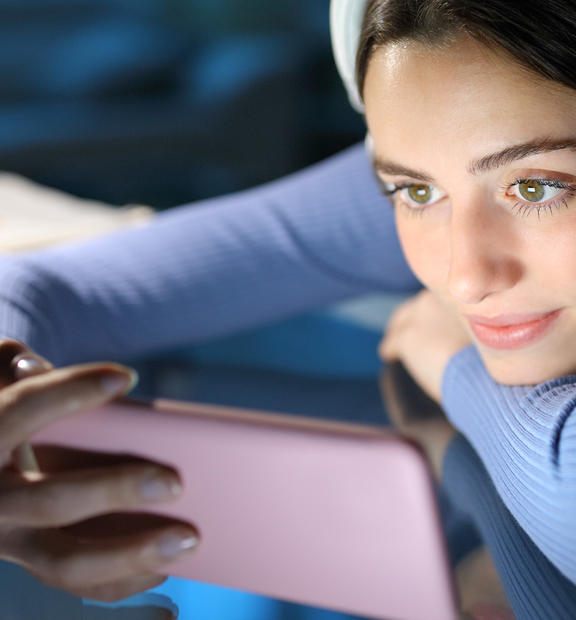 Woman watching media on smartphone in home environment