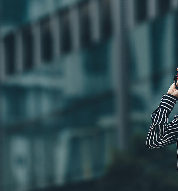 Asian woman walking in the city talking on mobile phone