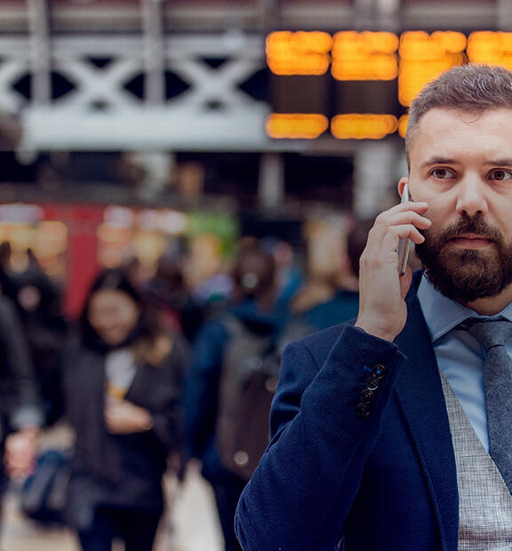 Busy businessman with smartphone, making phone call at airport