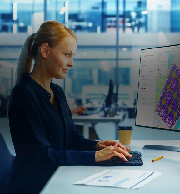 Woman in modern office looking at Infovista's Planet Cloud report