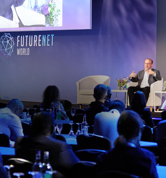 Rick Hamilton, CEO of Infovista, sits with Anita Tadayon, COO of Virgin Media O2, and Roy Chua of AvidThink during a fireside chat discussing practical AI implementation beyond the hype.