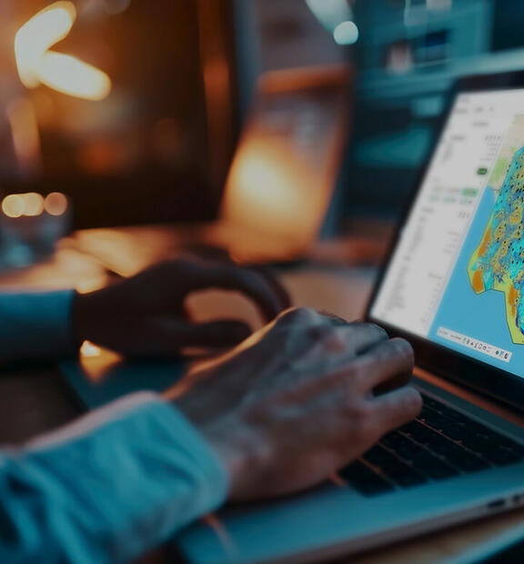 Business professional using Planet Cloud on laptop to design and optimize fixed wireless access (FWA) networks faster.