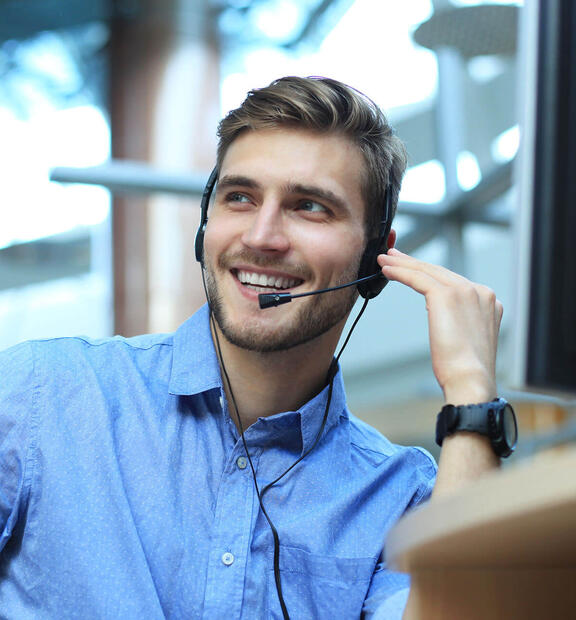 Man with headset talking on the phone at a helpdesk 