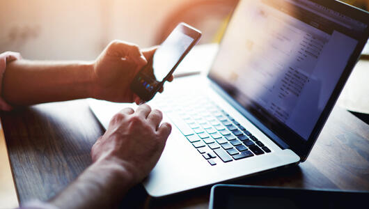 Man on laptop and phone