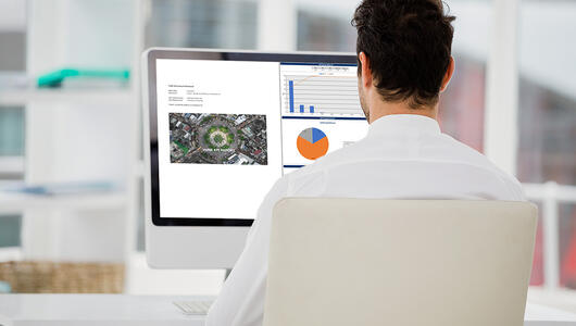 Man looking at report builder on screen