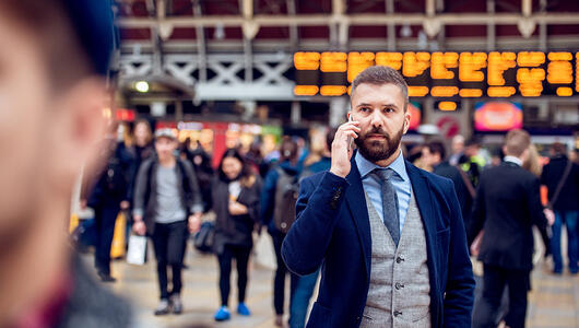 Busy businessman with smartphone, making phone call at airport