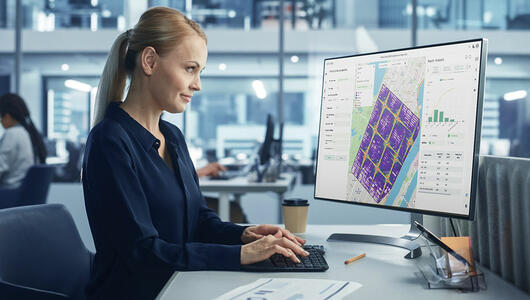 Woman in office looking at Infovista's Planet Cloud report