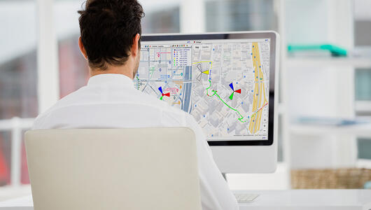 Man working from office looking at TEMS Discovery 3D map view on his desk monitor