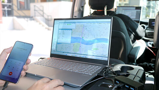 Network performance drive testing in city with TEMS Investigation tool inside test van.
