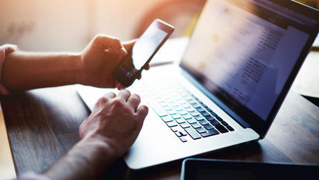 Man on laptop and phone
