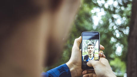 young man making a selfie outdoors with smartphone