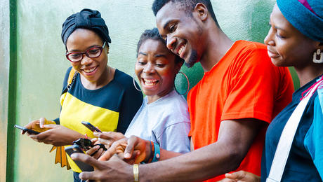 Happy youngsters looking at phones