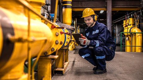 Industrial technician checking gas pipeline installations inside refinery