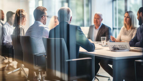 A group of business partners engaged in a meeting inside a modern conference room