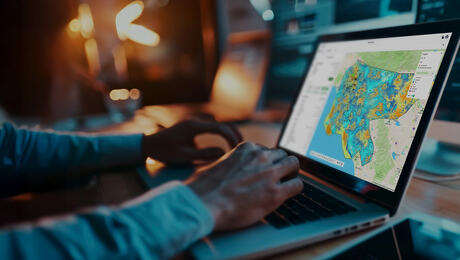 Business professional using Planet Cloud on laptop to design and optimize fixed wireless access (FWA) networks faster.