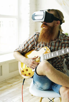 Guy playing guitar wearing VR glasses